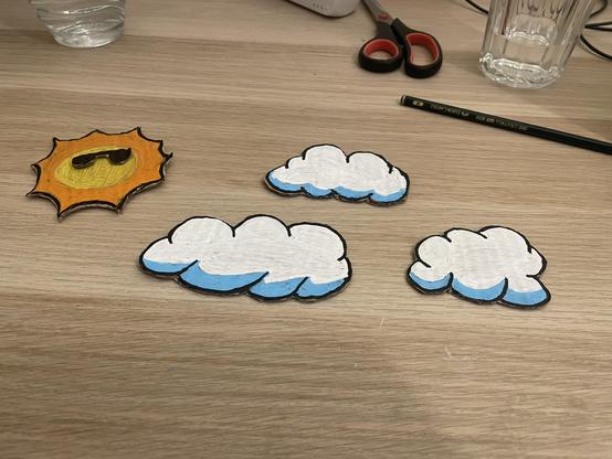 the sun and clouds from the demo as actual cardboard objects on a table