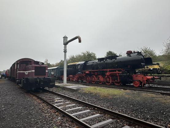 Der Museumszug links neben dem Wasserkran, rechts steht eine Dampflok der Baureihe 52