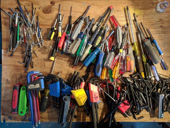 Dozens of Allen wrenches and drivers lined up on a table