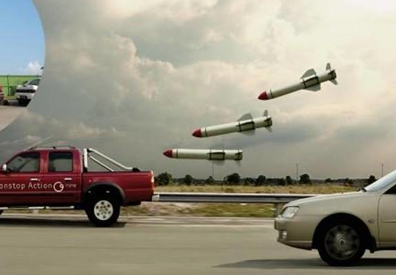 Ein roter Pickuptruck wird von mehreren angehängten Ballons, die aussehen wie Raketen "verfolgt".